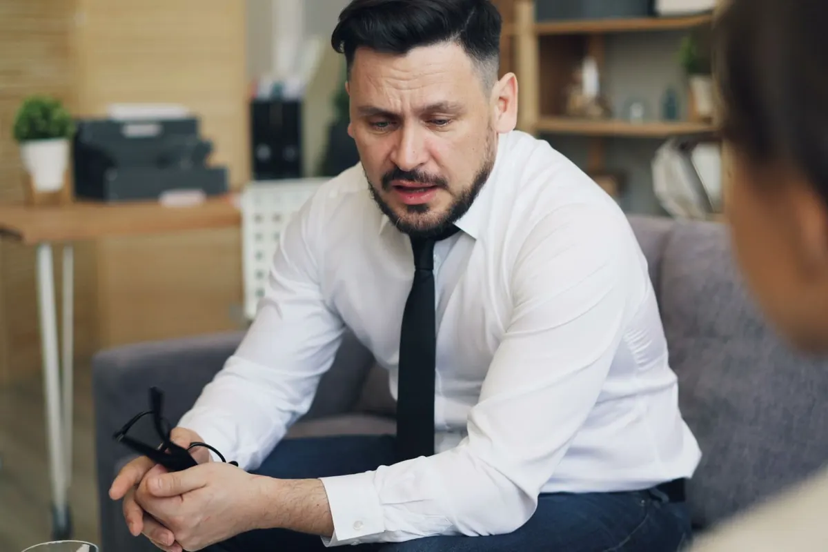 Psicoterapeuta conversa con un consultante en un consultorio tranquilo
