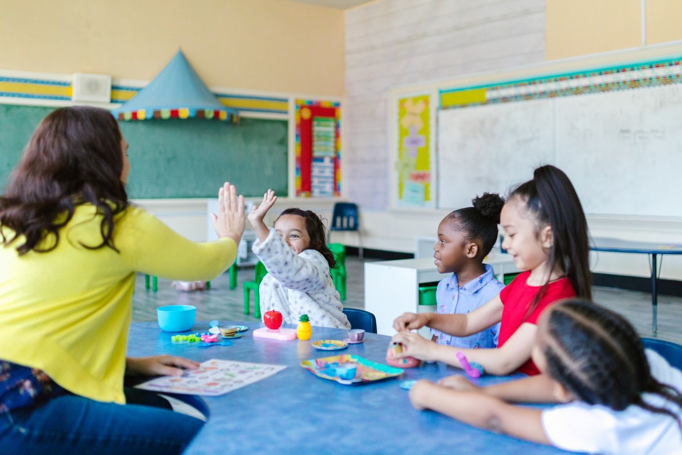 Docente trabajando con niños en un salón de clase